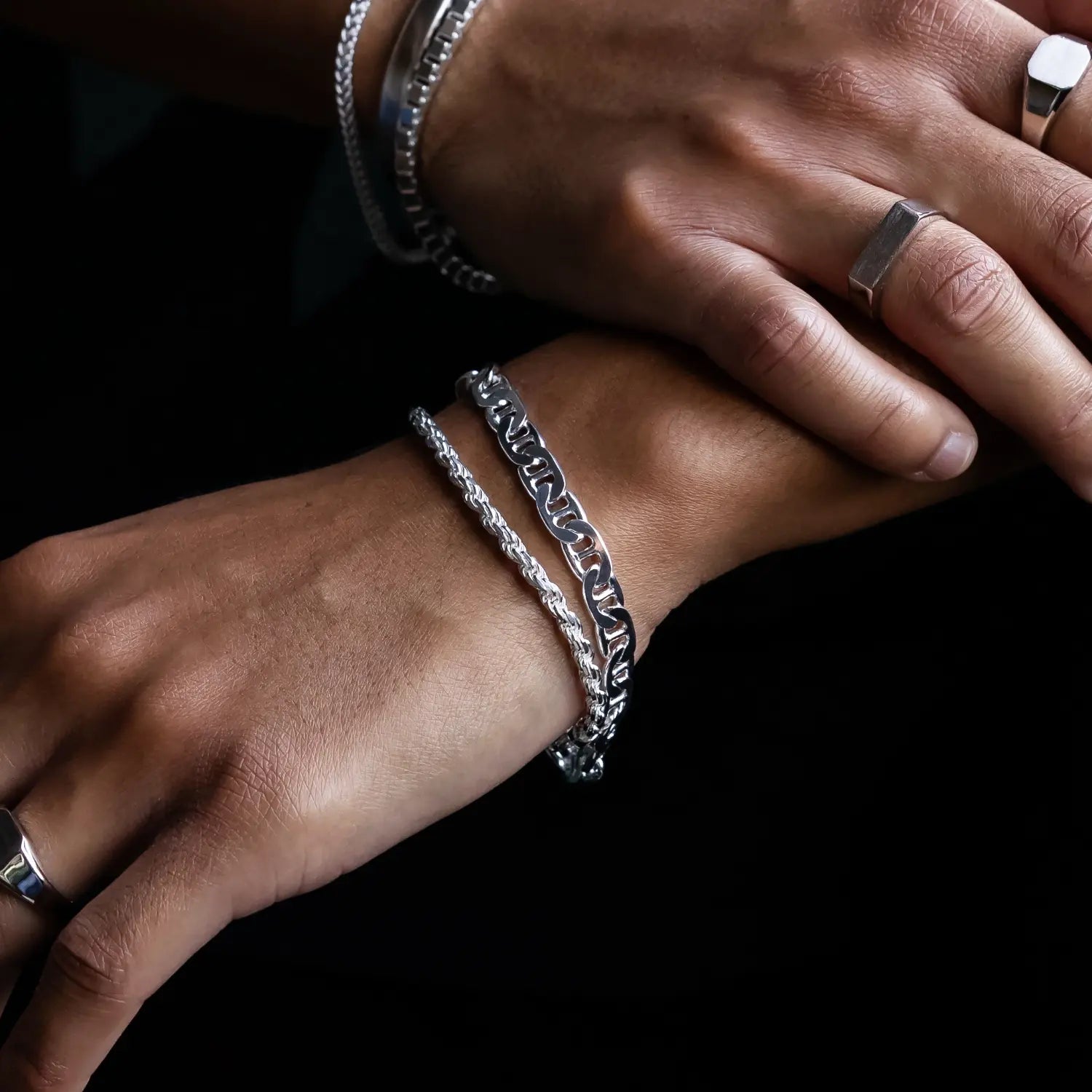 925 silver diamond cut rope chain bracelet stacked with sterling silver mariner link bracelet on one hand