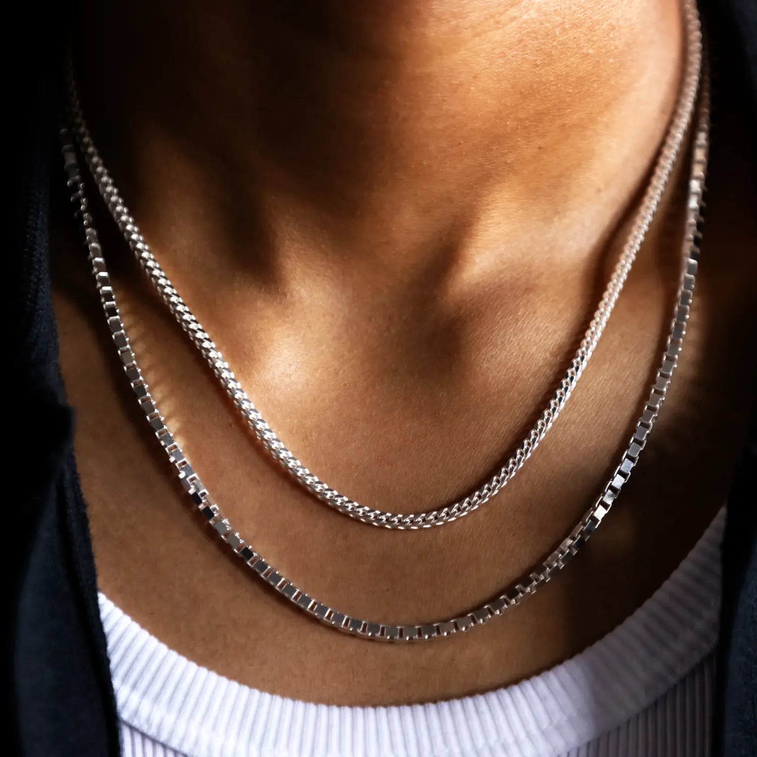 front close up angle of 20" 925 silver box link chain stacked with 925 sterling silver 18" franco link chain
