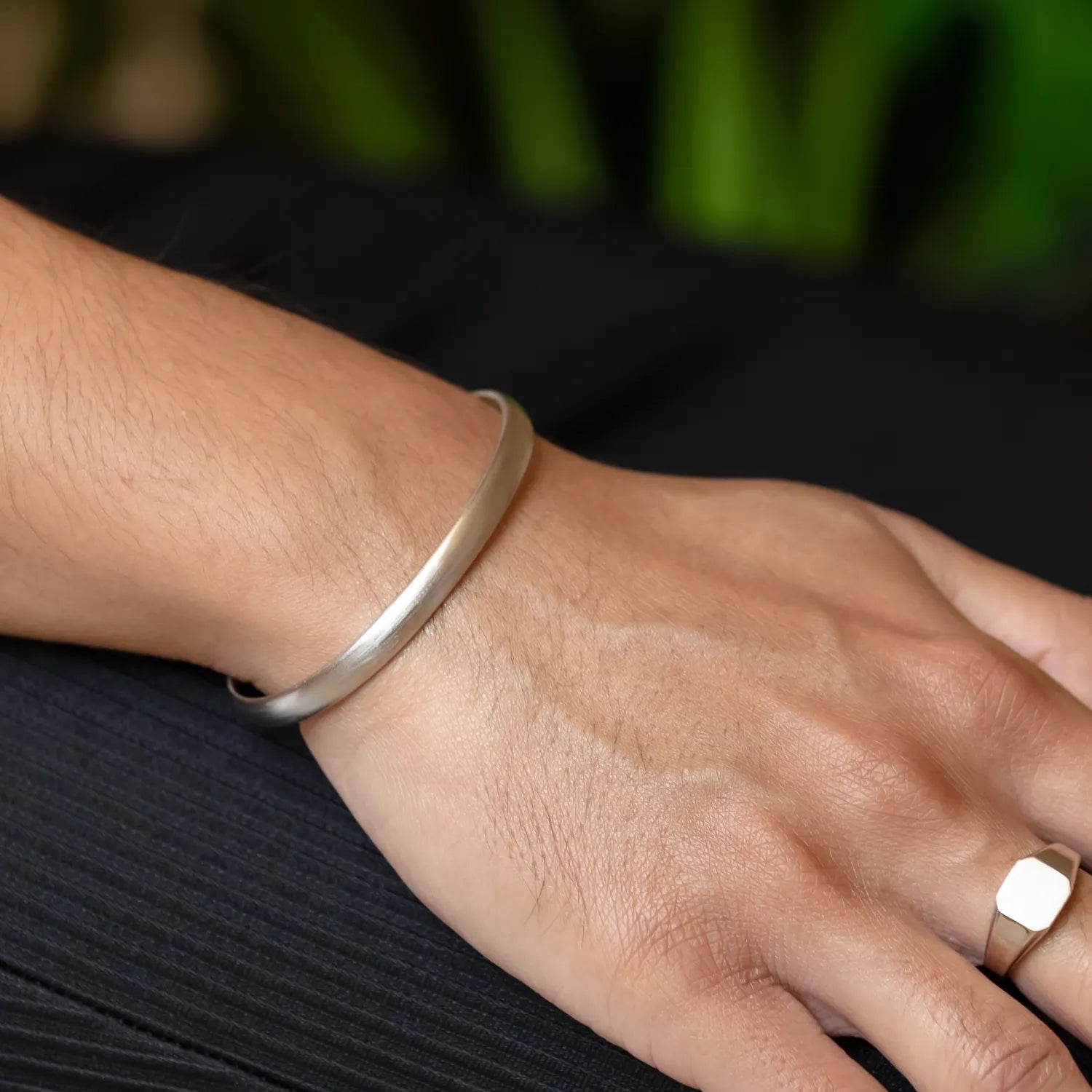925 silver adjustable cuff bangle on right resting on top of plissé pants