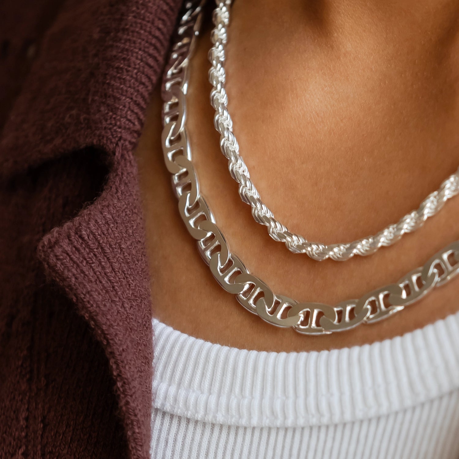 close up of 925 silver mariner link chain necklace stacked with 925 silver diamond cut rope chain